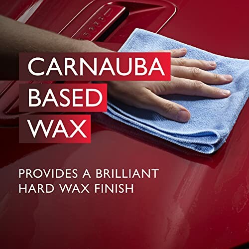 Hand polishing red car with carnauba wax using blue cloth.