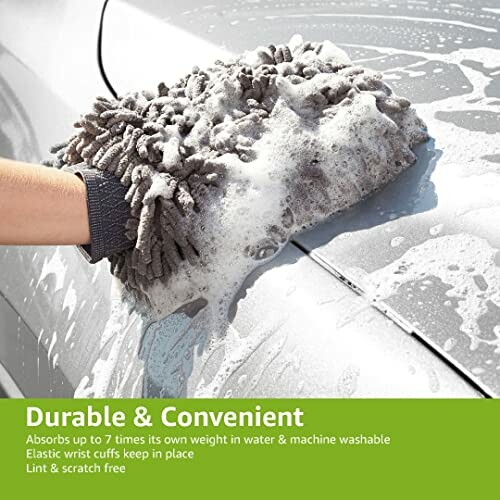 Microfiber wash mitt cleaning a car with soap suds.